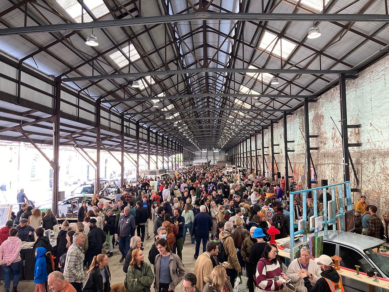 The interior of Carriageworks with market stalls beneath the industrial roof.